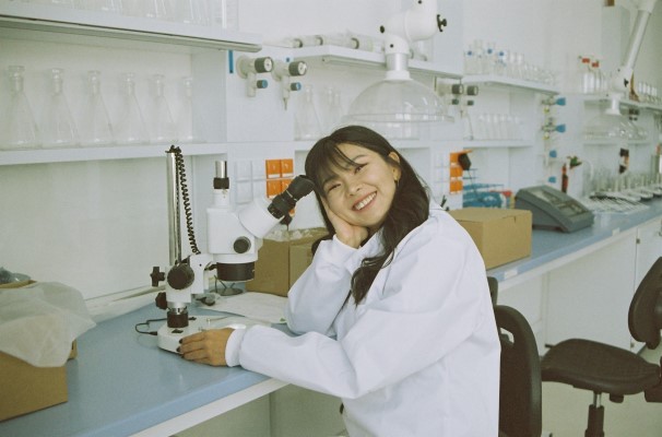 A woman smiling at the desk in a lab