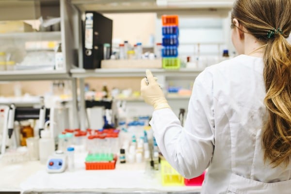 Bilde av en kvinne som arbeider i et laboratorium med prøver